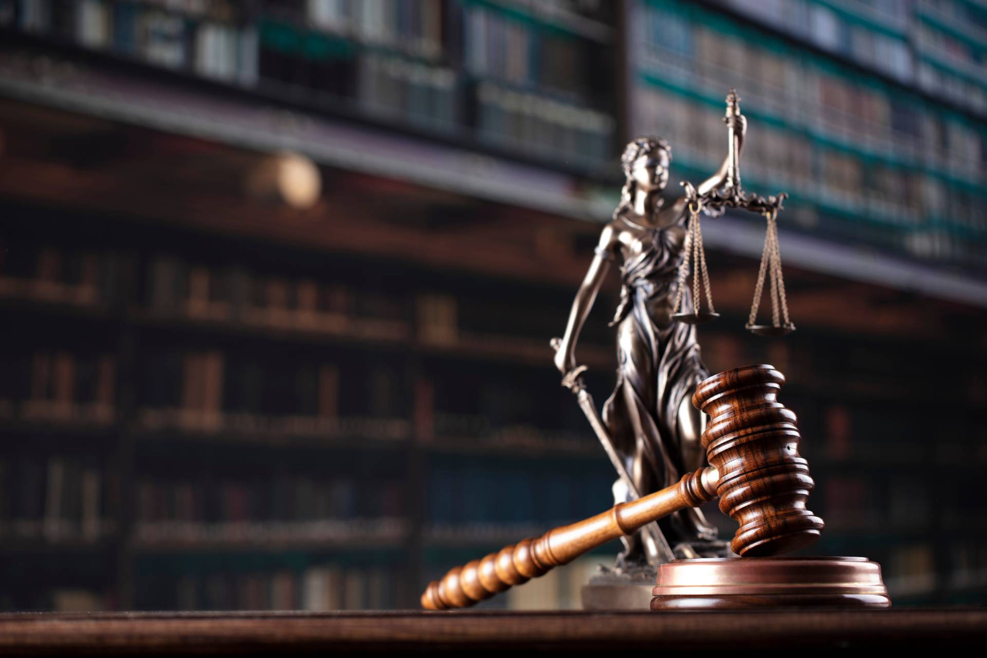 Judge's gavel with Lady Justice statue and law books