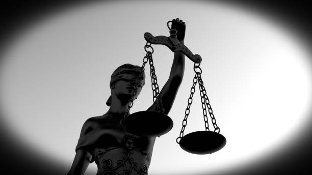 Silhouette of Lady Justice statue in dramatic lighting